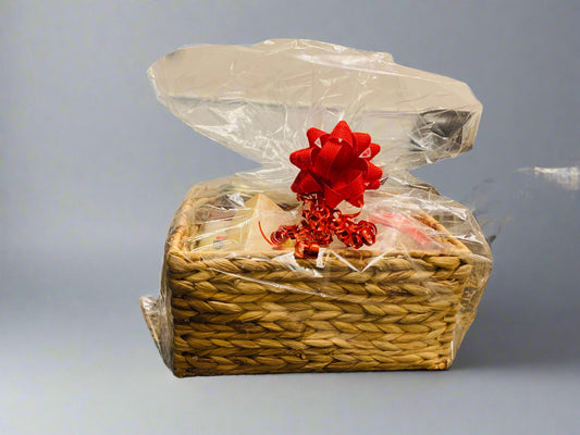 Wicker basket with clear plastic wrap and a red bow on a gray background